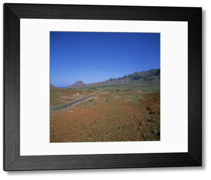 Framed Print : Road across a volcanic crater, with small buildings in the distance, inland on the island of Sao Vicente, Republic of Cape Verde Islands Framed Print : Road across a volcanic crater, with small buildings in the distance, inland on the island of Sao Vicente, Republic of Cape Verde Islands