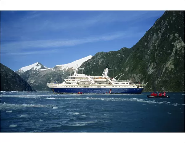Tourists in an inflatable boat and cruise ship in the Chilean fjords, Chile