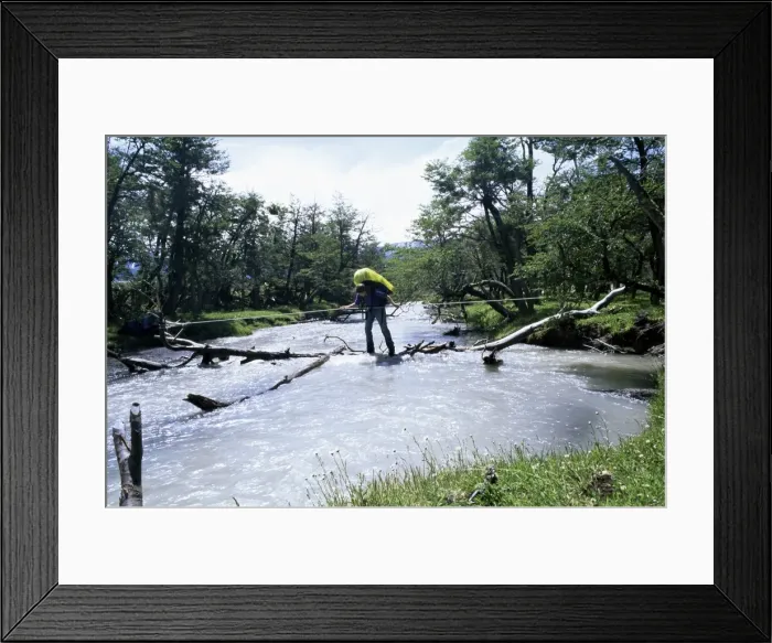Framed Print : Backpacker crosses log bridge on circuit around the park, Torres del Paine National Park Framed Print : Backpacker crosses log bridge on circuit around the park, Torres del Paine National Park