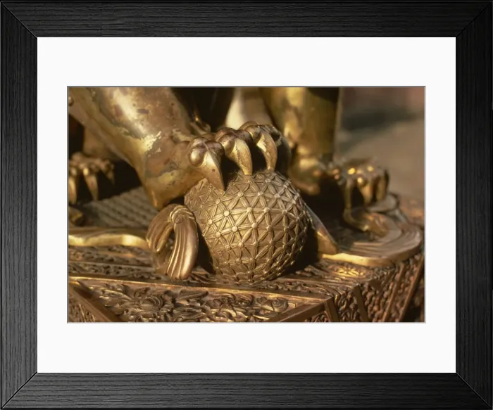 Framed Print : Close-up of the paw of a gilt bronze lion holding a fire ball, symbol of force Framed Print : Close-up of the paw of a gilt bronze lion holding a fire ball, symbol of force