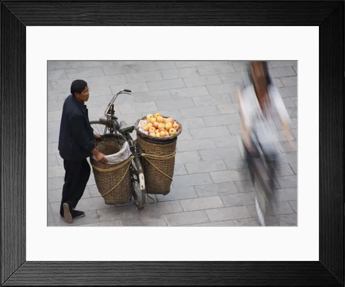 Framed Print : A fruit seller watching people pass by in the historic old town of Pingyao City Framed Print : A fruit seller watching people pass by in the historic old town of Pingyao City