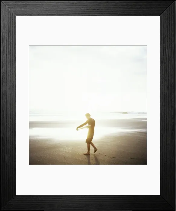 Framed Print : Young man waxes his board before entering Marabellas waves, Costa Rica Framed Print : Young man waxes his board before entering Marabellas waves, Costa Rica