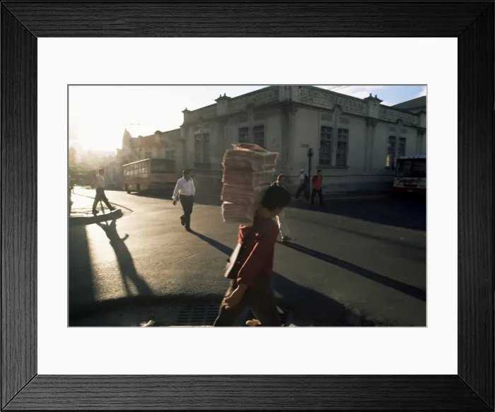 Framed Print : Morning activity on the streets, boy carrying newspapers, San Jose, Costa Rica Framed Print : Morning activity on the streets, boy carrying newspapers, San Jose, Costa Rica