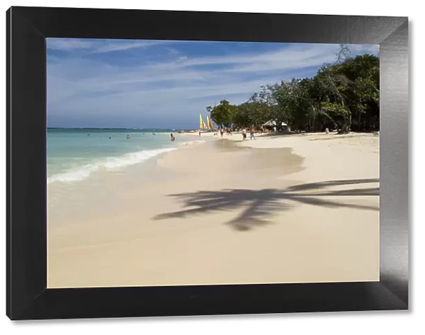 The shadow of a palm tree on the beach and emerald sea. Guardalavaca Beach, Guardalavaca, Cuba, West Indies, Central