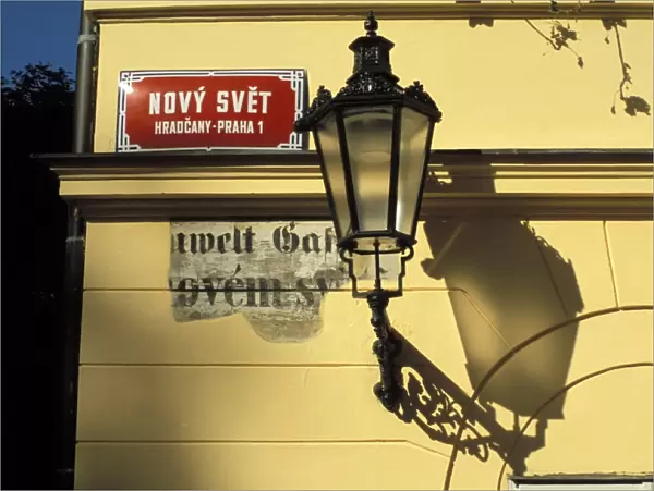 Close-up of current and historical street signs with lamp on a wall, Hradcany