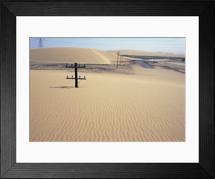 Framed Print : Migrating barchan sand dunes across road marked by buried telegraph poles Framed Print : Migrating barchan sand dunes across road marked by buried telegraph poles