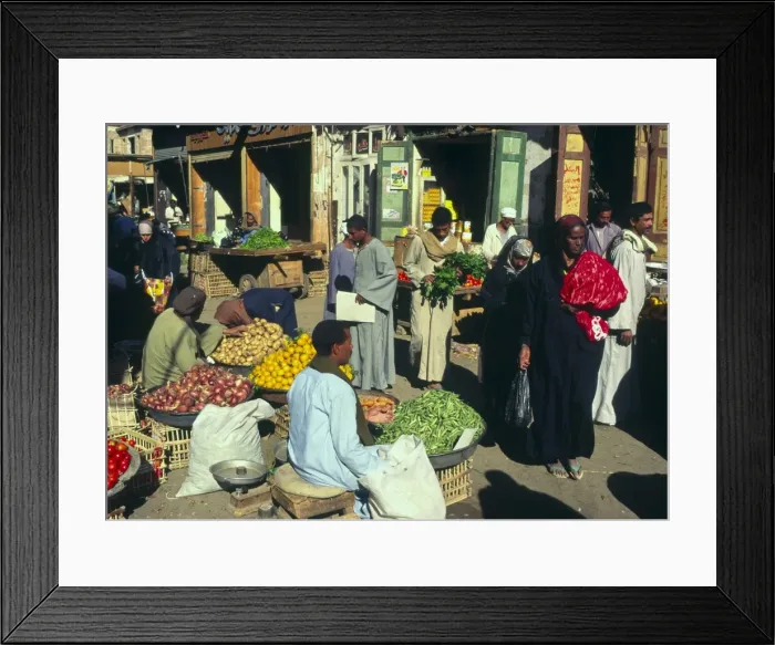 Framed Print : Hawker at vegetable and fruit stall with people passing by, local market Framed Print : Hawker at vegetable and fruit stall with people passing by, local market