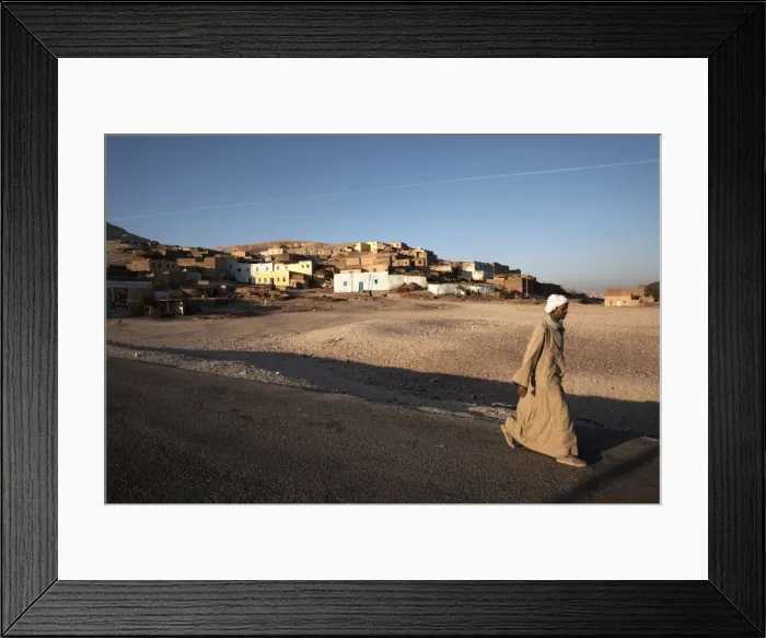 Framed Print : A man walks past a village on the West Bank of Luxor, Egypt, North Africa, Africa Framed Print : A man walks past a village on the West Bank of Luxor, Egypt, North Africa, Africa