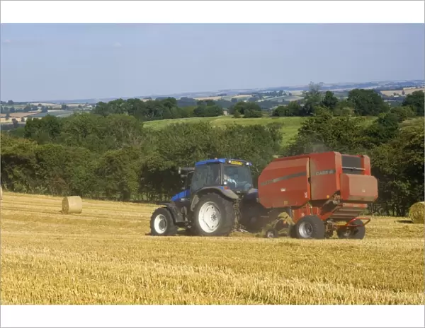 Tractor collecting hay bales at harvest time, seen from the Cotswolds Way footpath