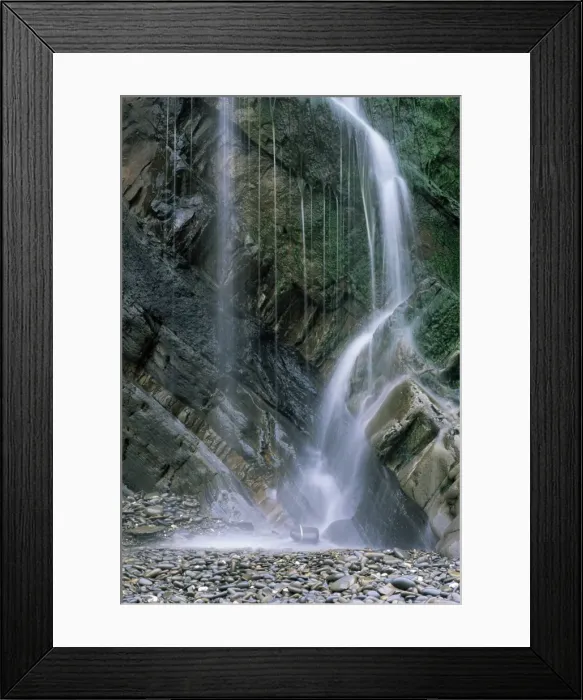 Framed Print : Waterfall with wet rocks and pebbles taken from beach, Cornwall, England Framed Print : Waterfall with wet rocks and pebbles taken from beach, Cornwall, England
