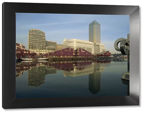 Canary Wharf and modern art sculpture reflected in pond, Docklands, London
