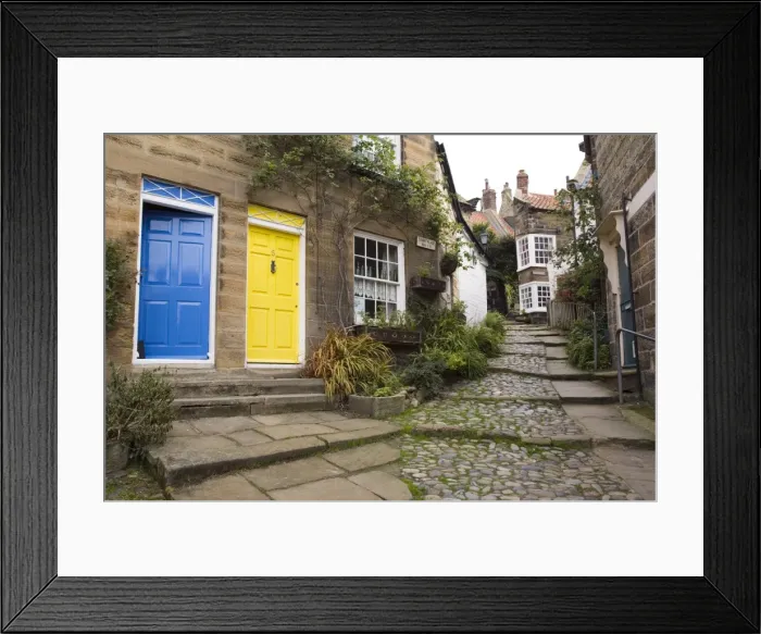 Framed Print : Yellow and blue doors on houses in The Opening, a narrow stepped cobbled alley on steep hill in Old Bay part of the fishing village, Robin Hoods Bay, Yorkshire, England, United Framed Print : Yellow and blue doors on houses in The Opening, a narrow stepped cobbled alley on steep hill in Old Bay part of the fishing village, Robin Hoods Bay, Yorkshire, England, United