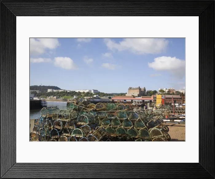 Framed Print : Lobster pots by Old Harbour in South Bay with hotels on South Cliff beyond Framed Print : Lobster pots by Old Harbour in South Bay with hotels on South Cliff beyond