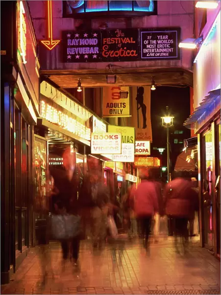Exterior of sex shops and signs in red light area at night, Soho, London