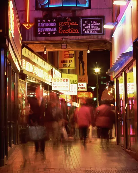 Exterior of sex shops and signs in red light area at night, Soho, London