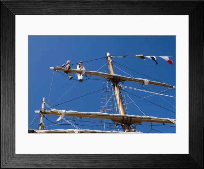 Framed Print : Detail of main mast of tall ship with two seamen on top yard securing sail Framed Print : Detail of main mast of tall ship with two seamen on top yard securing sail