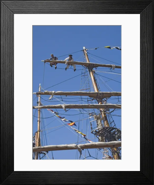 Framed Print : Detail of main mast of tall ship with two seamen on top yard securing sail Framed Print : Detail of main mast of tall ship with two seamen on top yard securing sail