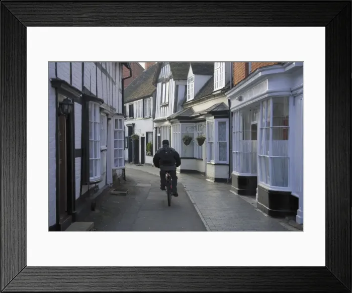 Framed Print : Man cycling along narrow street, Alcester, Warwickshire, Midlands, England Framed Print : Man cycling along narrow street, Alcester, Warwickshire, Midlands, England
