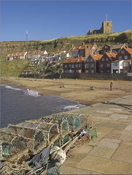 Whitby church, sandy beach and lobster pots on quayside, Whitby, North Yorkshire