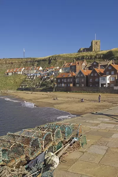 Whitby church, sandy beach and lobster pots on quayside, Whitby, North Yorkshire