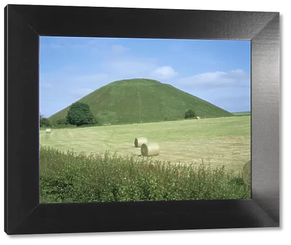 Baled hay in field below Silbury Hill, Wiltshire, England, United Kingdom, Europe