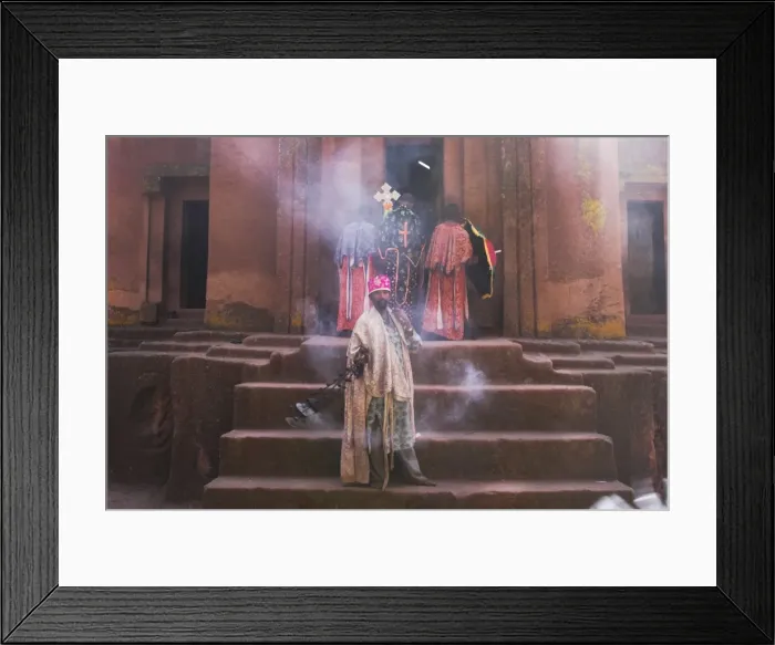 Framed Print : Priest swings an incense burner at the rock-hewn monolithic church of Bet Giyorgis (St