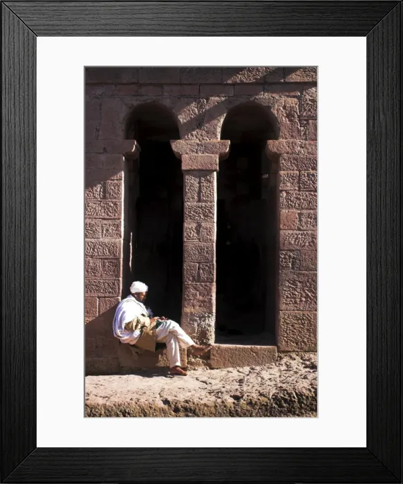Framed Print : Pilgrim sits in early morning sun reading his Holy Bible at entrance doors to Bet Maryam church Framed Print : Pilgrim sits in early morning sun reading his Holy Bible at entrance doors to Bet Maryam church