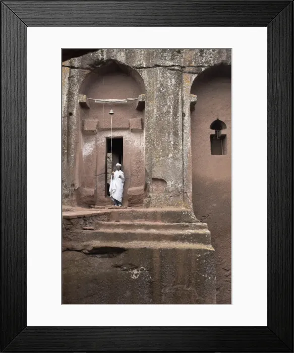 Framed Print : A priest stands at the entrance to the rock-hewn church of Bet Gabriel-Rufael Framed Print : A priest stands at the entrance to the rock-hewn church of Bet Gabriel-Rufael