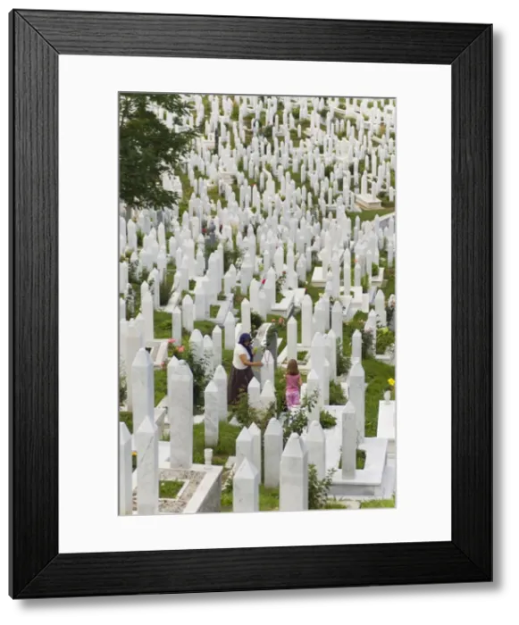 Framed Print : Muslim woman and child tend a grave at a war cemetery, Sarajevo, Bosnia Framed Print : Muslim woman and child tend a grave at a war cemetery, Sarajevo, Bosnia