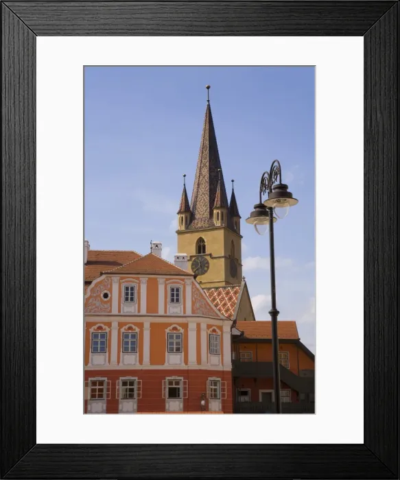 Framed Print : Colourfully painted houses and the Evangelical church, Piata Huet, in the 12th century Saxon city Framed Print : Colourfully painted houses and the Evangelical church, Piata Huet, in the 12th century Saxon city