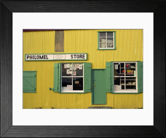 Framed Print : Brightly painted yellow corrugated wall and green wooden building of the general store selling hardware and gifts, Stanley, Falkland Islands