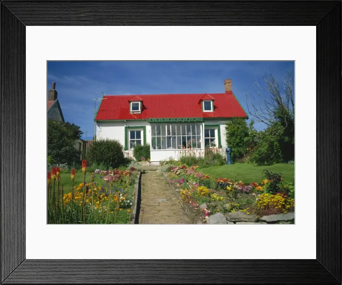Framed Print : Flower beds line a brick path up to a typical private house, with bright red corrugated roof Framed Print : Flower beds line a brick path up to a typical private house, with bright red corrugated roof