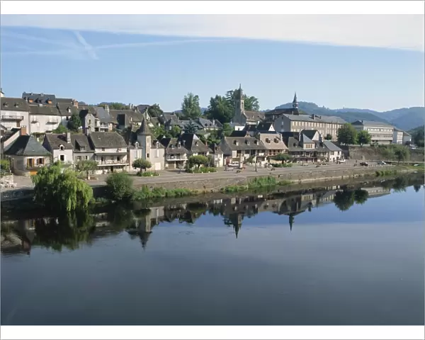 Reflections in the River Dordogne of houses and churches of Argentat in Correze