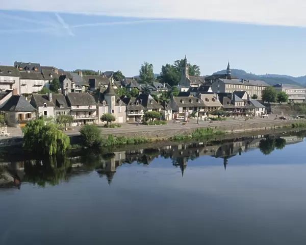 Reflections in the River Dordogne of houses and churches of Argentat in Correze