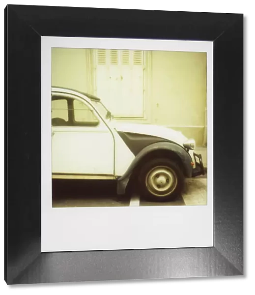 Polaroid of old black and white Citroen 2CV parked on street, Paris, France, Europe