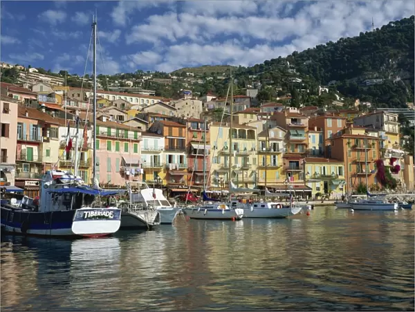 Boats in the harbour and painted houses on the waterfront in the town of Villefranche