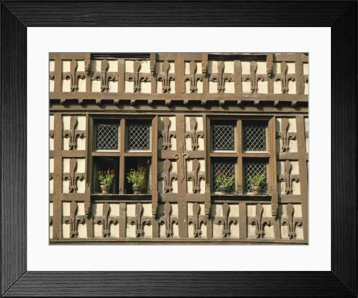 Framed Print : Detail of fleur-de-lys motif carved in wood on the timber framed Market Hall in the village of Arreau, Midi-Pyrenees
