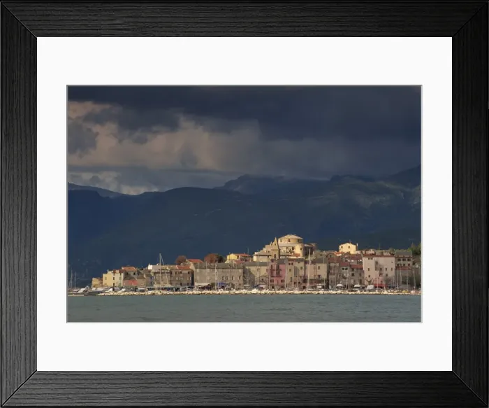Framed Print : Dark clouds over hills and the skyline of the town of St. Florent on Cap Corse on the island of Corsica, France Framed Print : Dark clouds over hills and the skyline of the town of St. Florent on Cap Corse on the island of Corsica, France