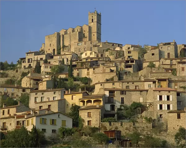 Christian church on the skyline and houses in the village of Eus, Languedoc Roussillon
