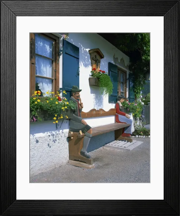 Framed Print : Figures carved on a bench on a decorative house front Framed Print : Figures carved on a bench on a decorative house front