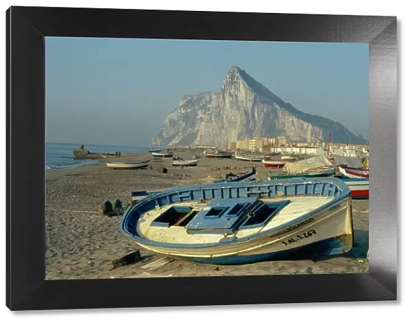 Boats pulled onto beach below the Rock of Gibraltar