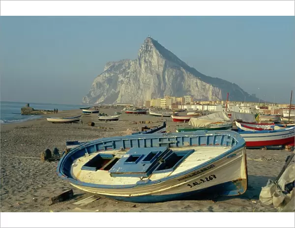 Boats pulled onto beach below the Rock of Gibraltar