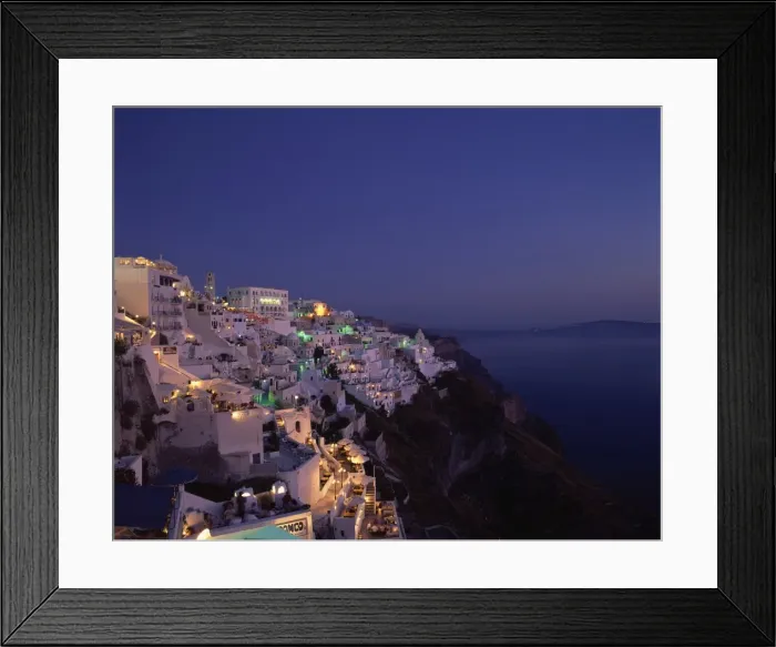 Framed Print : Aerial view over the illuminated houses of Fira Town at dusk Framed Print : Aerial view over the illuminated houses of Fira Town at dusk