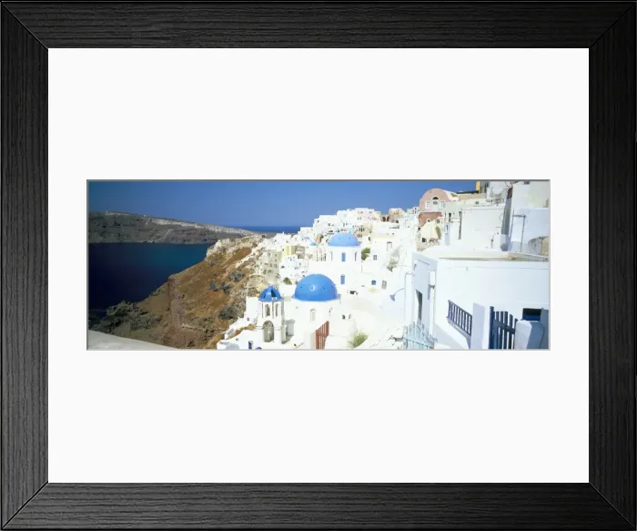 Framed Print : View of Oia with blue domed churches and whitewashed buildings Framed Print : View of Oia with blue domed churches and whitewashed buildings