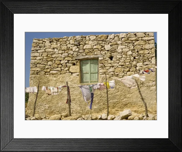 Framed Print : Washing line in front of an old stone wall with small