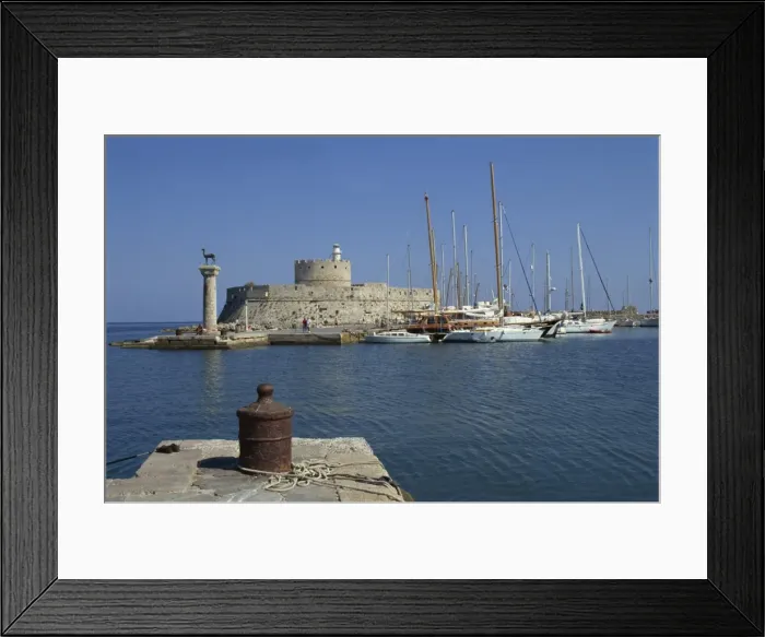Framed Print : The entrance to Mandraki Harbour, with one of the buck statues and St Framed Print : The entrance to Mandraki Harbour, with one of the buck statues and St