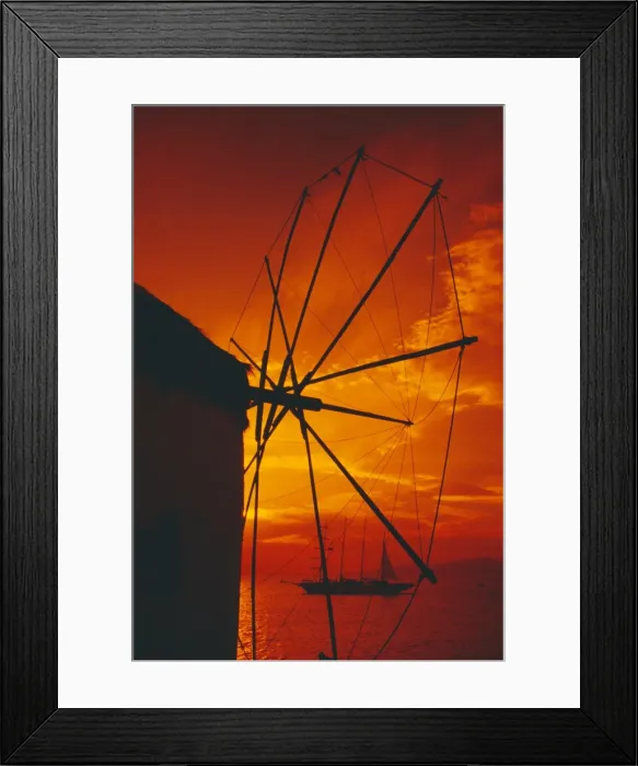 Framed Print : Silhouette of a windmill at sunset and boat in the background Framed Print : Silhouette of a windmill at sunset and boat in the background