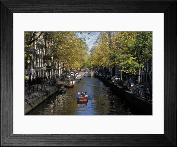 Framed Print : Small boat on tree-lined Oudezijds Achtenburg Wal canal in the autumn Framed Print : Small boat on tree-lined Oudezijds Achtenburg Wal canal in the autumn