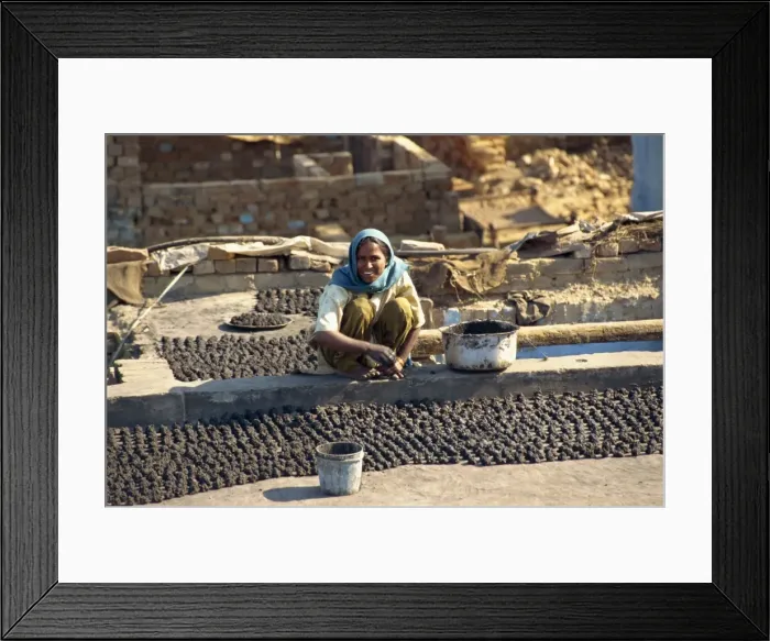 Framed Print : Woman making dung pats for fuel Framed Print : Woman making dung pats for fuel