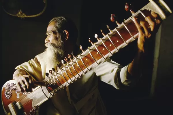 Portrait of an elderly man playing the sitar